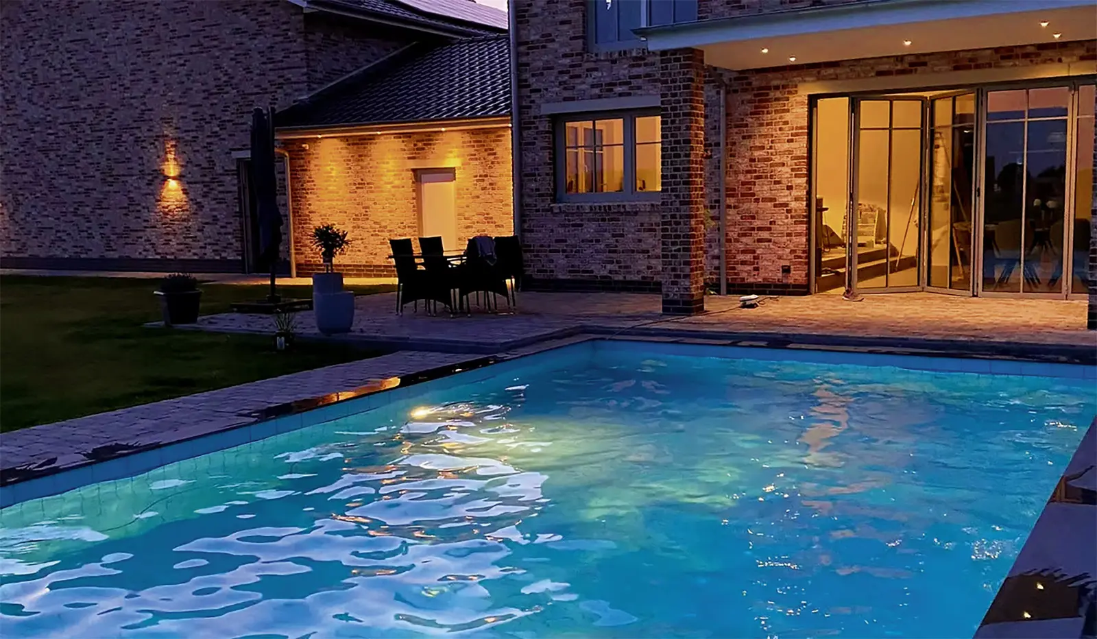 Haus mit Pool außen bei Nacht